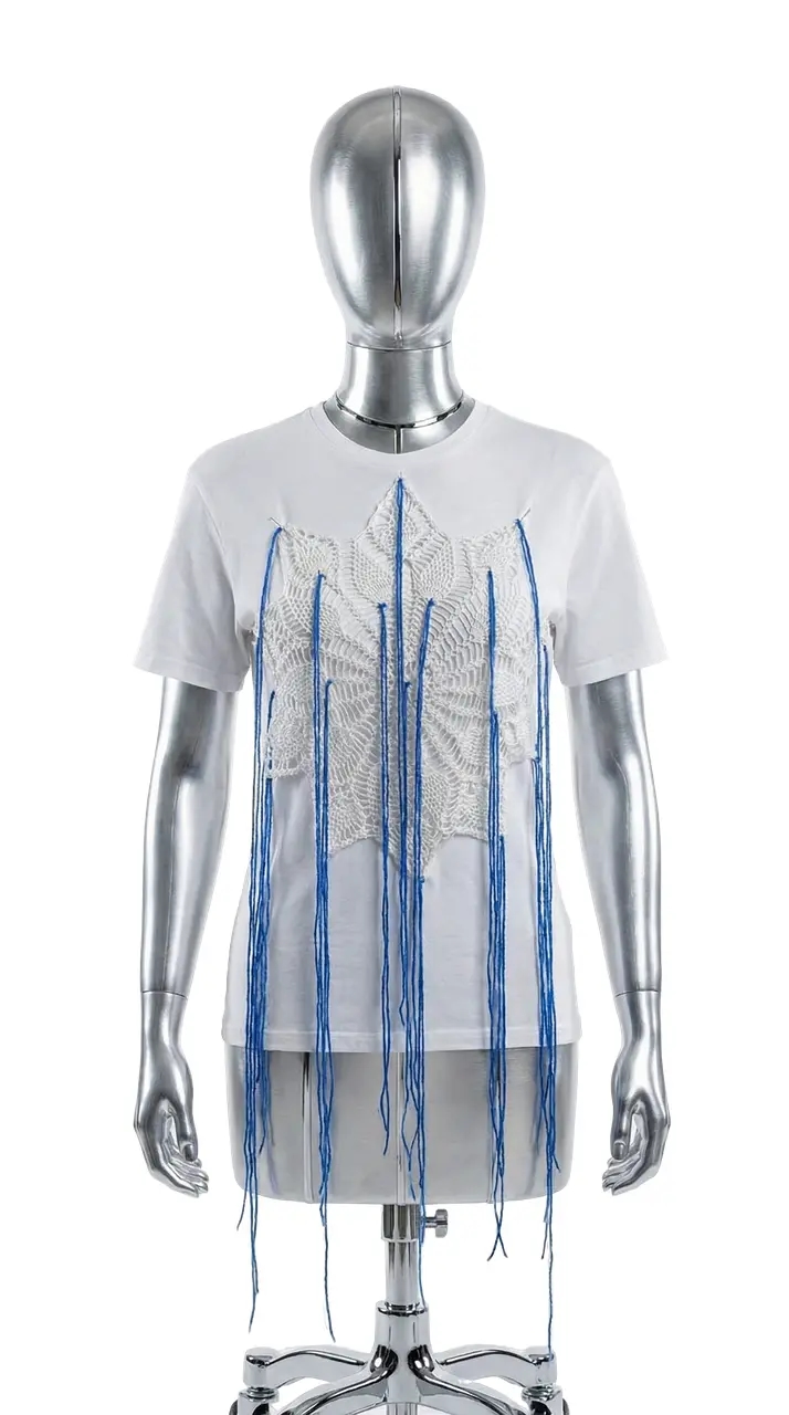 Белая хлопковая футболка с вязаной салфеткой и длинными синими нитями спереди.