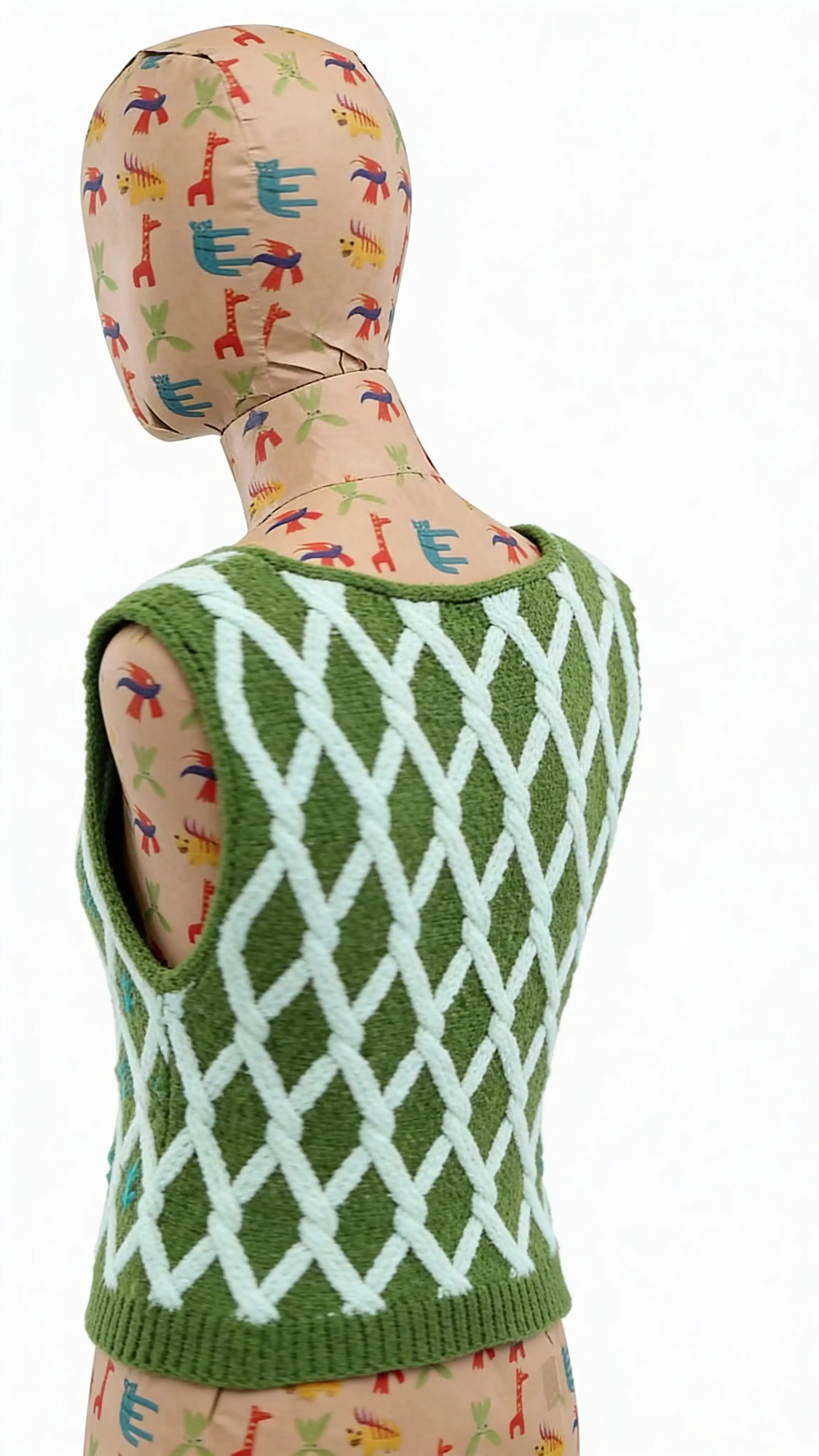 Вязаная арт-жилетка с геометрическим орнаментом и мотивом колосков, вписанных в структуру полотна. Ритмичный узор формирует сетку из линий и повторяющихся символов, создавая ощущение порядка, роста и природного цикла.
Орнамент выполнен в технике вязки, а не принта: каждый элемент является частью структуры изделия. Контраст зелёного фона и светлого узора подчёркивает природную тему и отсылает к архаичным и сельским мотивам, переосмысленным в современном дизайнерском ключе.
Жилетка подходит для многослойных образов и может носиться как самостоятельная вещь или поверх рубашек и лонгсливов.