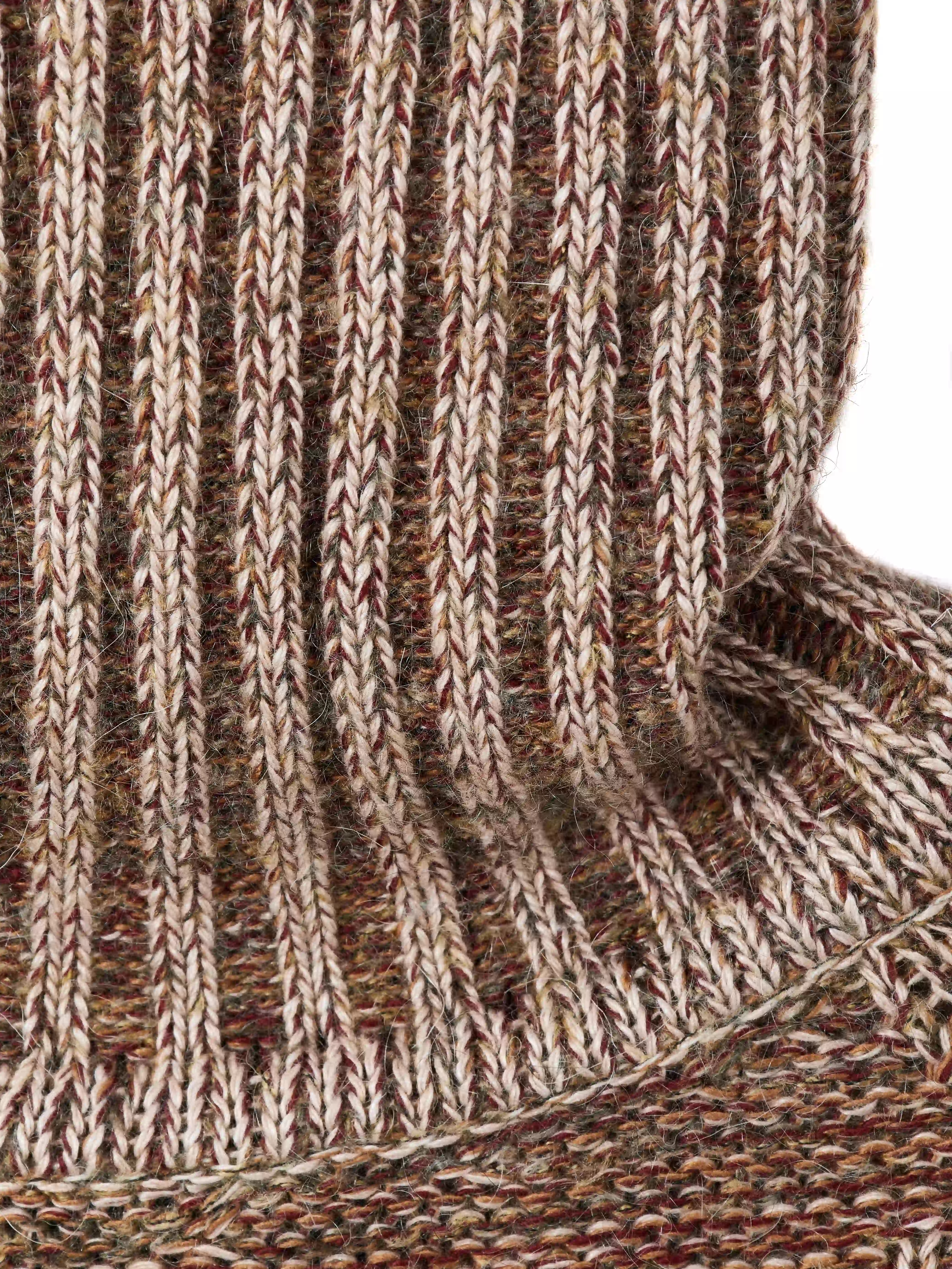 Модель вдохновлена образом «дедушкиного свитера» — тёплой ностальгической вещью с выраженным характером. Объёмный силуэт с рукавом реглан сочетает неравномерные косы и ромбовидный узор. Высокий воротник-резинка хорошо держит форму и защищает от холода. Свитер выполнен в технике платировочного вязания с использованием двух нитей, создающих эффект наслоения и выразительную фактуру.
Изделие связано из итальянской пряжи на основе шерсти с добавлением вискозы и мохера. Материал сохраняет тепло и остаётся комфортным для повседневной носки. Финальная технологическая стирка раскрывает структуру волокон, делая полотно мягким и приятным на ощупь.