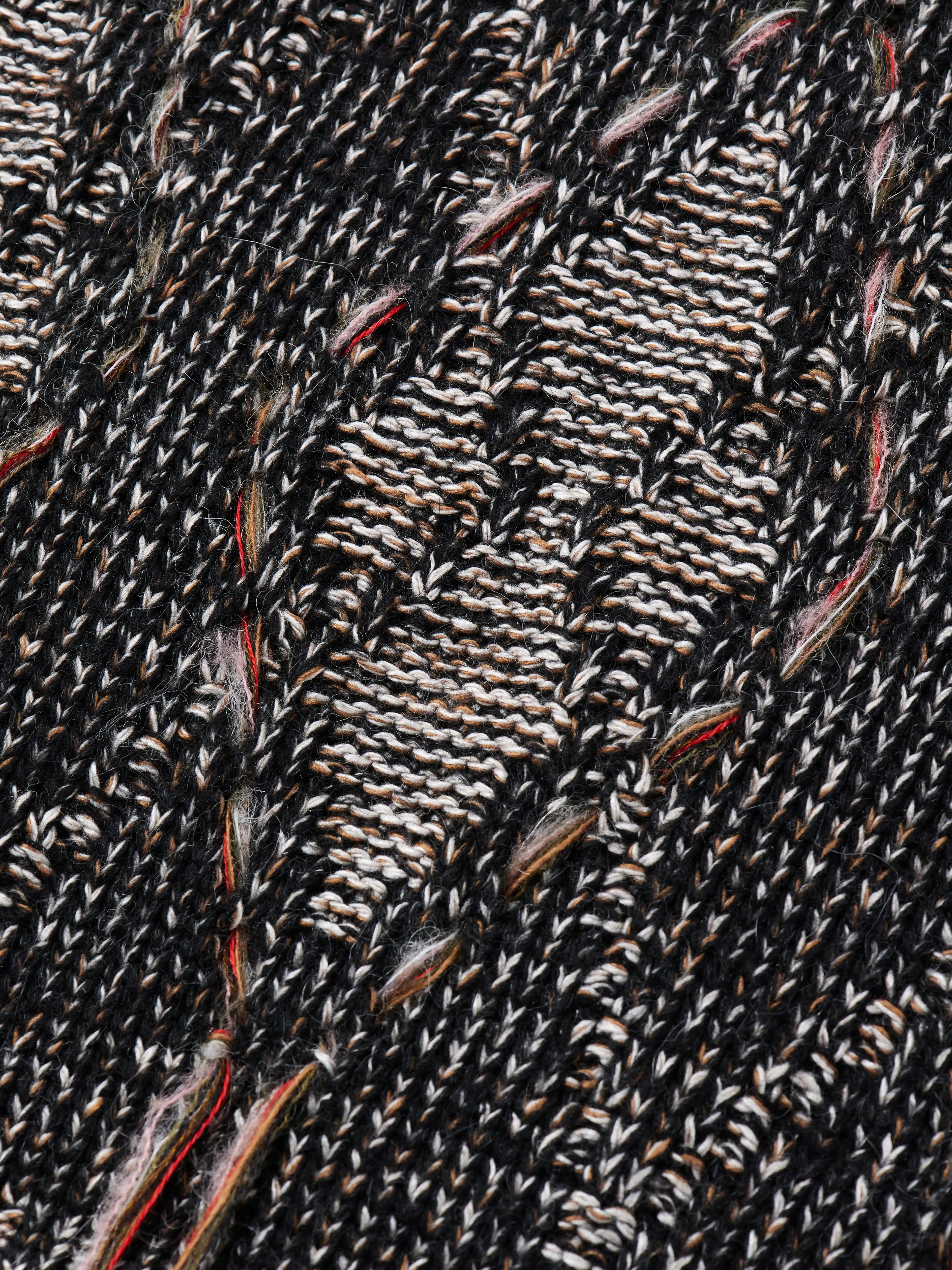 Джемпер расслабленного силуэта со спущенным рукавом. Основное полотно выполнено кулирной гладью, а на рукавах и в нижней части фактурными петлями вывязан рисунок ромбов. Контуры ромбов обрамлены ажурными отверстиями, через которые вручную протянуты фактурные нити, создавая эффект вышивки.
Для производства выбрана высококачественная итальянская пряжа: натуральная шерсть дополнена вискозой и нежным мохером. Такой состав обеспечивает комфорт в повседневной носке. Каждое изделие проходит специальный цикл технологической стирки с особыми составами — это раскрывает структуру волокон, делая полотно мягким и приятным на ощупь.
В коллекции модель представлена в монохромной гамме: в полотне сочетаются нити чёрного, коричневого и светло-серого оттенков.