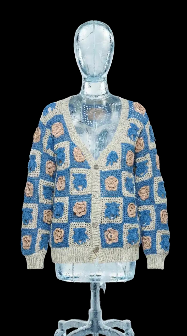 Кардиган связан крючком из хлопка в технике бабушкин квадрат. Модель собрана из отдельных квадратов с рельефными мотивами — фирменные Чихпауки и розы чередуются, формируя узнаваемый графический орнамент.
Свободный унисекс-силуэт, V-образный вырез и застёжка на декоративные пуговицы в виде паутины делают модель удобной и выразительной.
Серо-синяя цветовая гамма в сочетании с бежевыми элементами подчёркивает фактуру ручной вязки и делает мотивы Чихпауков особенно выразительными — графично, спокойно и современно.