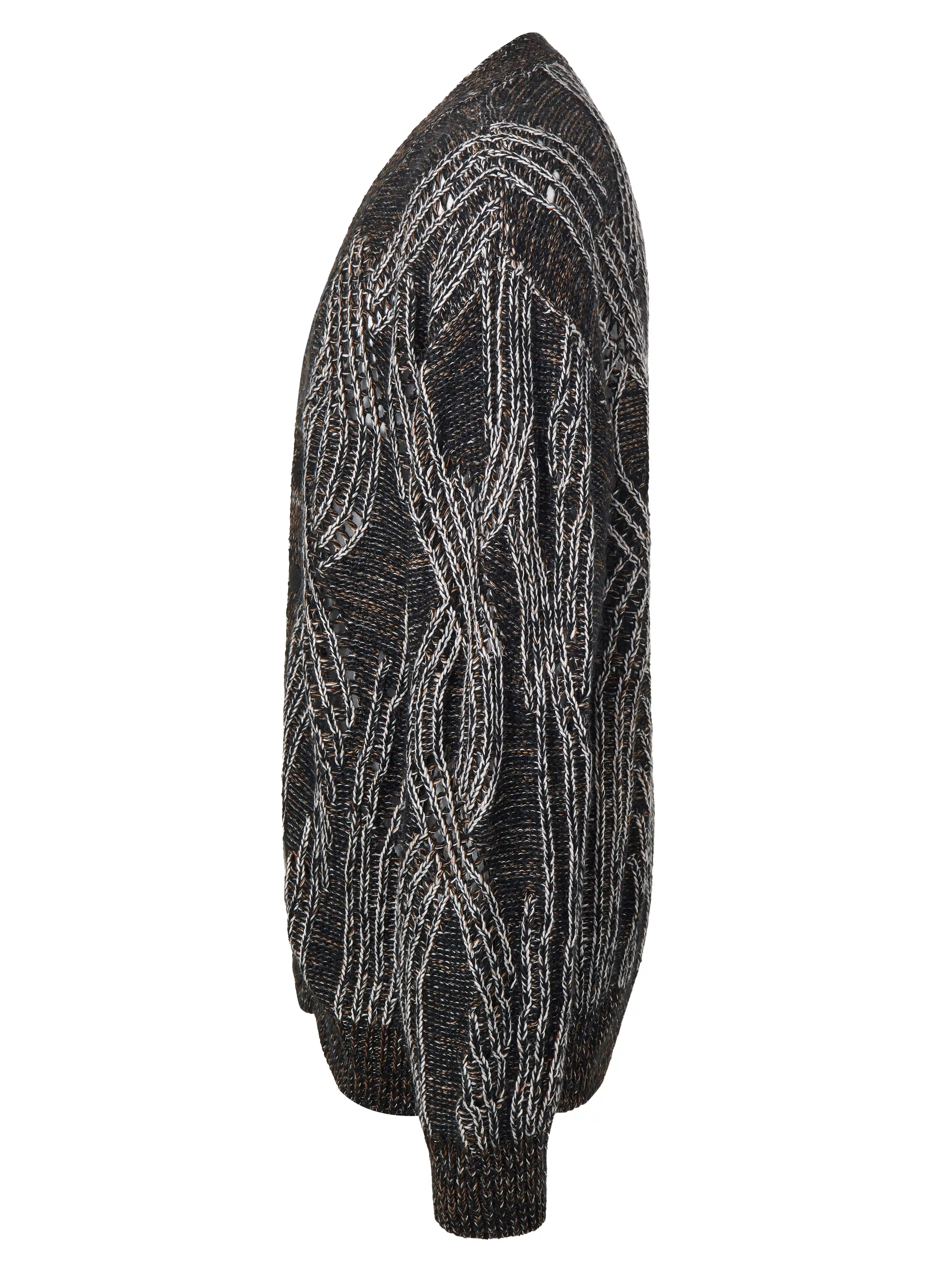 Кардиган на пуговицах выполнен в технике платировочного вязания, которая создаёт выразительный контраст между рисунком и основным полотном. Благодаря эффекту инверсии цвета модель можно носить на обе стороны. Фактурные косы с воздушным ажуром задают эффектный характер образа, что позволяет легко сочетать кардиган с лаконичными базовыми вещами.
Кардиган связан из высококачественной итальянской пряжи: натуральная шерсть в составе дополнена вискозой и нежным мохером. Такой состав вместе со свободным силуэтом обеспечивает высокий комфорт в носке. Каждое изделие проходит специальный цикл технологической стирки с использованием особых составов — процедура раскрывает структуру волокон, делая полотно мягким и приятным на ощупь.
В коллекции модель представлена в монохромной гамме: в полотне сочетаются нити чёрного, коричневого и светло-серого оттенков.