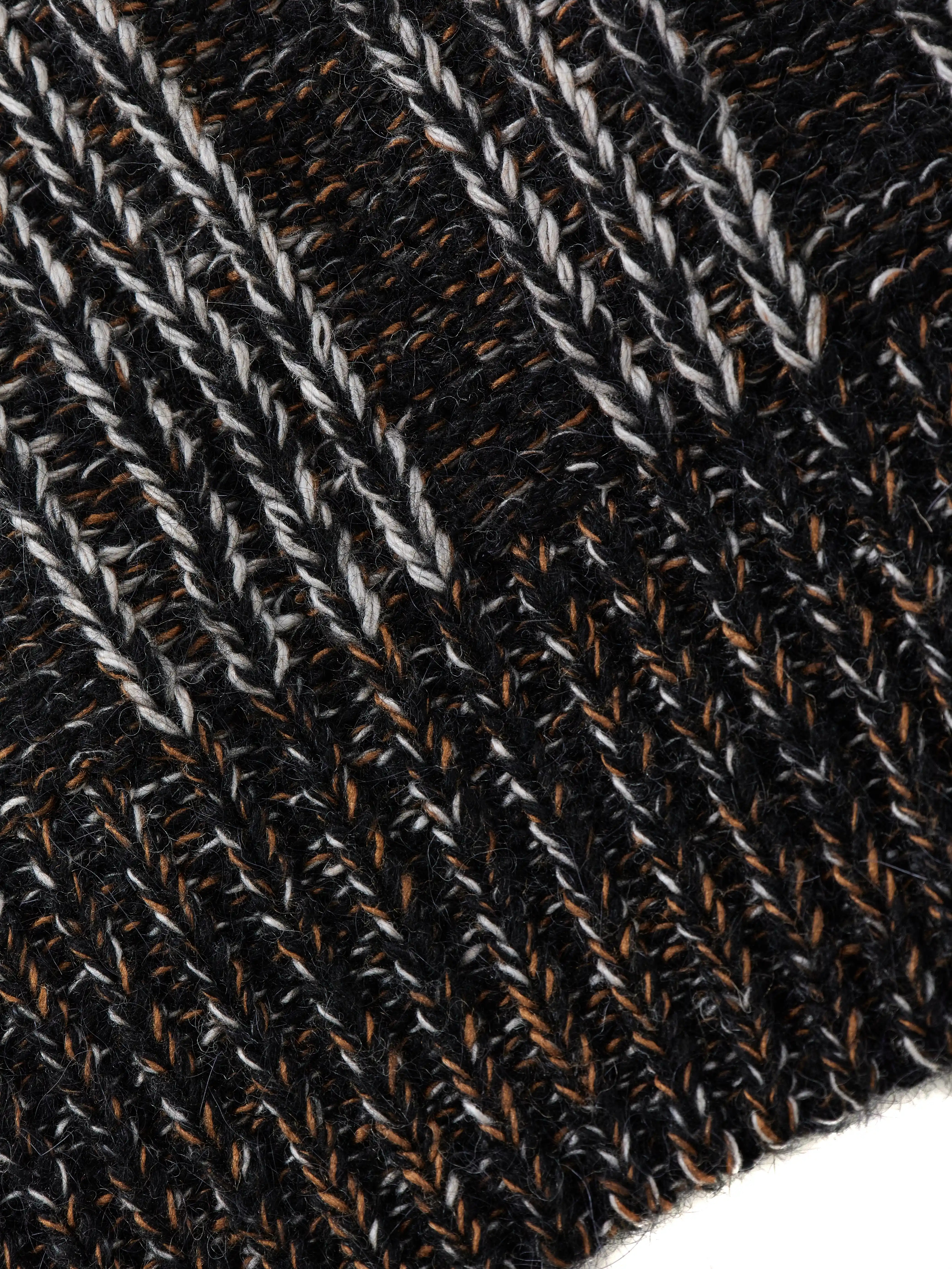 Кардиган на пуговицах выполнен в технике платировочного вязания, которая создаёт выразительный контраст между рисунком и основным полотном. Благодаря эффекту инверсии цвета модель можно носить на обе стороны. Фактурные косы с воздушным ажуром задают эффектный характер образа, что позволяет легко сочетать кардиган с лаконичными базовыми вещами.
Кардиган связан из высококачественной итальянской пряжи: натуральная шерсть в составе дополнена вискозой и нежным мохером. Такой состав вместе со свободным силуэтом обеспечивает высокий комфорт в носке. Каждое изделие проходит специальный цикл технологической стирки с использованием особых составов — процедура раскрывает структуру волокон, делая полотно мягким и приятным на ощупь.
В коллекции модель представлена в монохромной гамме: в полотне сочетаются нити чёрного, коричневого и светло-серого оттенков.