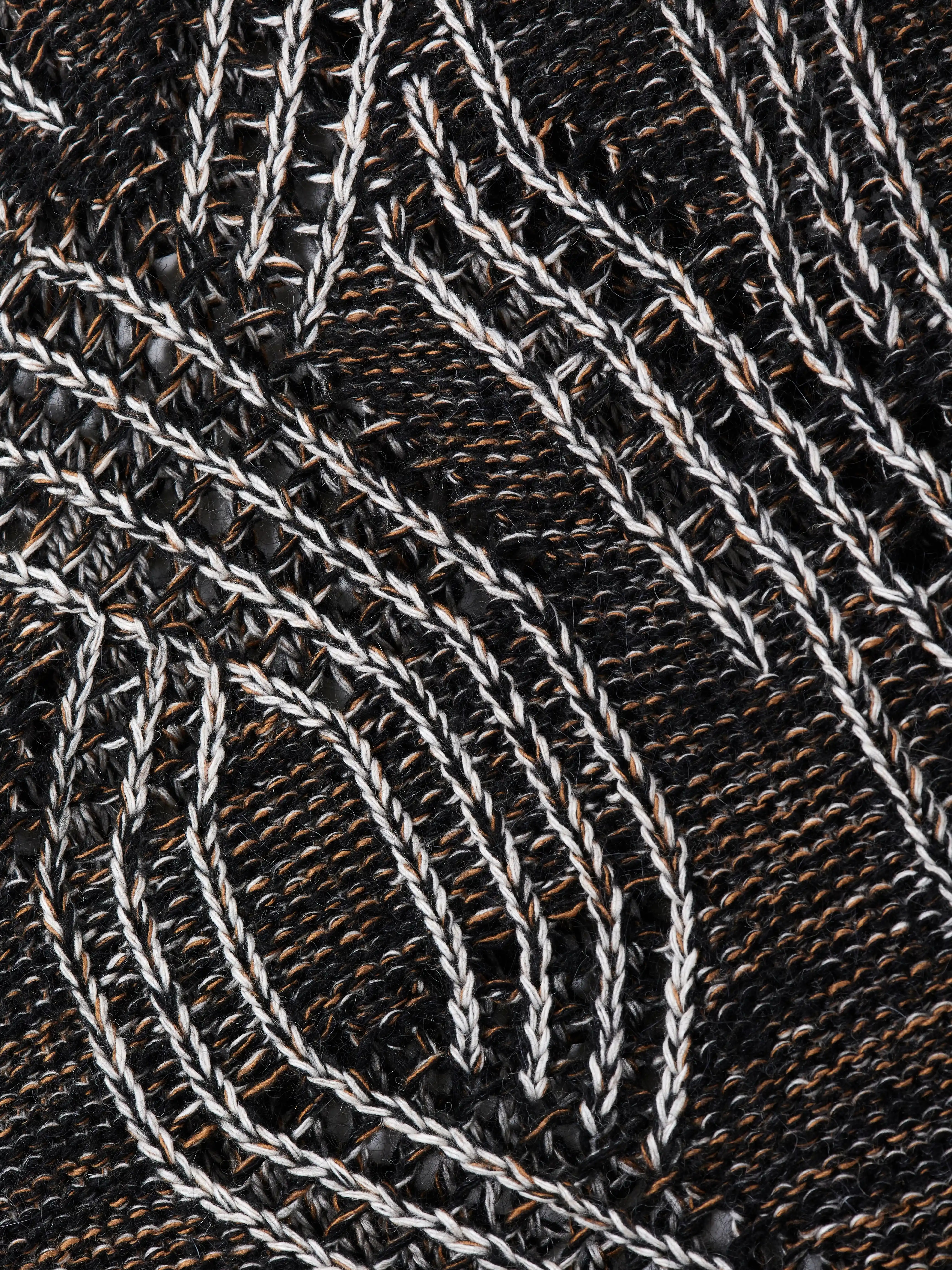 Кардиган на пуговицах выполнен в технике платировочного вязания, которая создаёт выразительный контраст между рисунком и основным полотном. Благодаря эффекту инверсии цвета модель можно носить на обе стороны. Фактурные косы с воздушным ажуром задают эффектный характер образа, что позволяет легко сочетать кардиган с лаконичными базовыми вещами.
Кардиган связан из высококачественной итальянской пряжи: натуральная шерсть в составе дополнена вискозой и нежным мохером. Такой состав вместе со свободным силуэтом обеспечивает высокий комфорт в носке. Каждое изделие проходит специальный цикл технологической стирки с использованием особых составов — процедура раскрывает структуру волокон, делая полотно мягким и приятным на ощупь.
В коллекции модель представлена в монохромной гамме: в полотне сочетаются нити чёрного, коричневого и светло-серого оттенков.