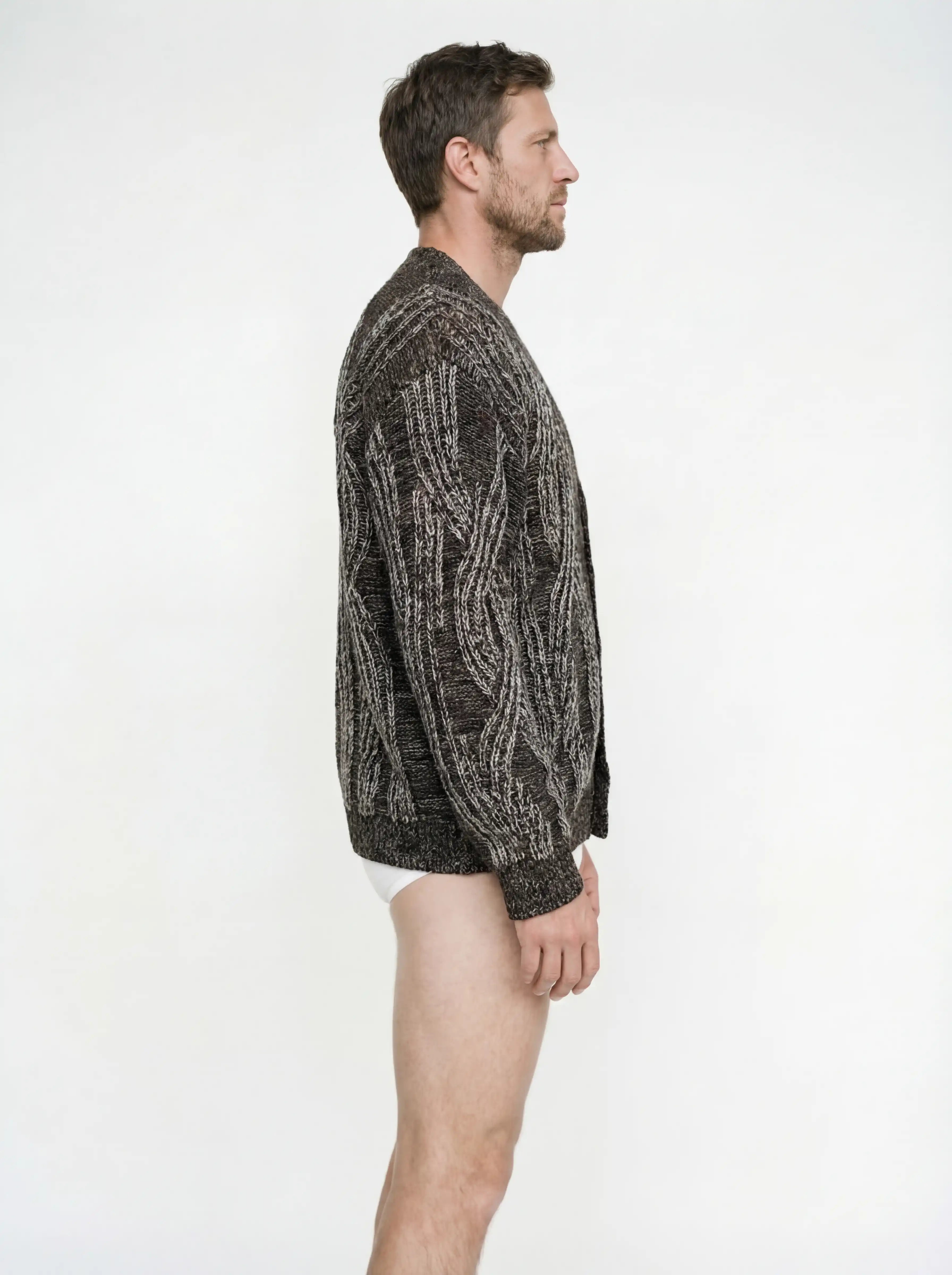 Кардиган на пуговицах выполнен в технике платировочного вязания, которая создаёт выразительный контраст между рисунком и основным полотном. Благодаря эффекту инверсии цвета модель можно носить на обе стороны. Фактурные косы с воздушным ажуром задают эффектный характер образа, что позволяет легко сочетать кардиган с лаконичными базовыми вещами.
Кардиган связан из высококачественной итальянской пряжи: натуральная шерсть в составе дополнена вискозой и нежным мохером. Такой состав вместе со свободным силуэтом обеспечивает высокий комфорт в носке. Каждое изделие проходит специальный цикл технологической стирки с использованием особых составов — процедура раскрывает структуру волокон, делая полотно мягким и приятным на ощупь.
В коллекции модель представлена в монохромной гамме: в полотне сочетаются нити чёрного, коричневого и светло-серого оттенков.