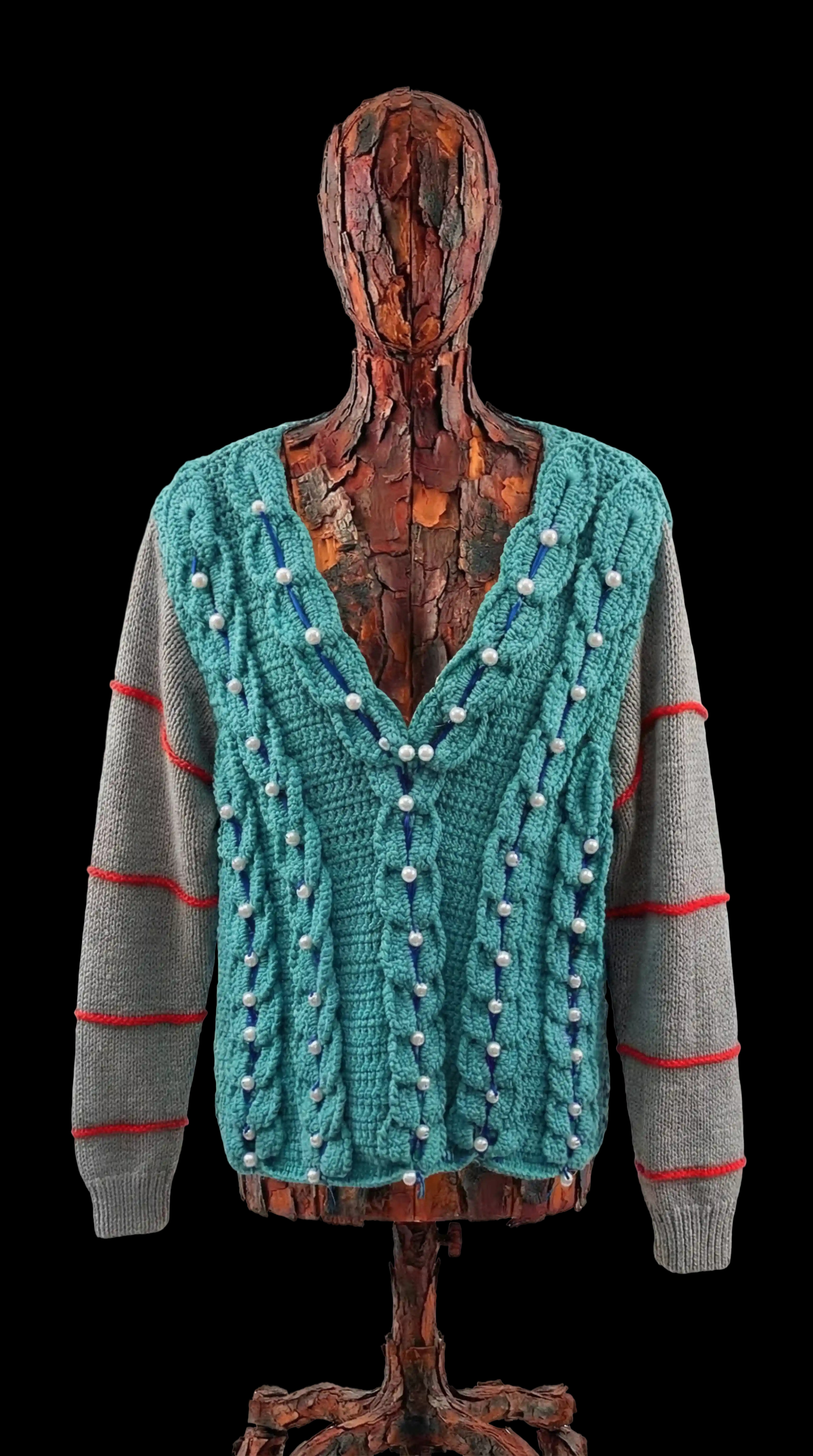 Свитер, будто его собирали по частям в другом мире. Мягкий бирюзовый перед связан объёмными «дорожками», по которым тянутся нити с бусинами — как жемчужины, которые аккуратно выносили деревянные существа из красного клёна, верустрицы, и бережно развесили по петлям.