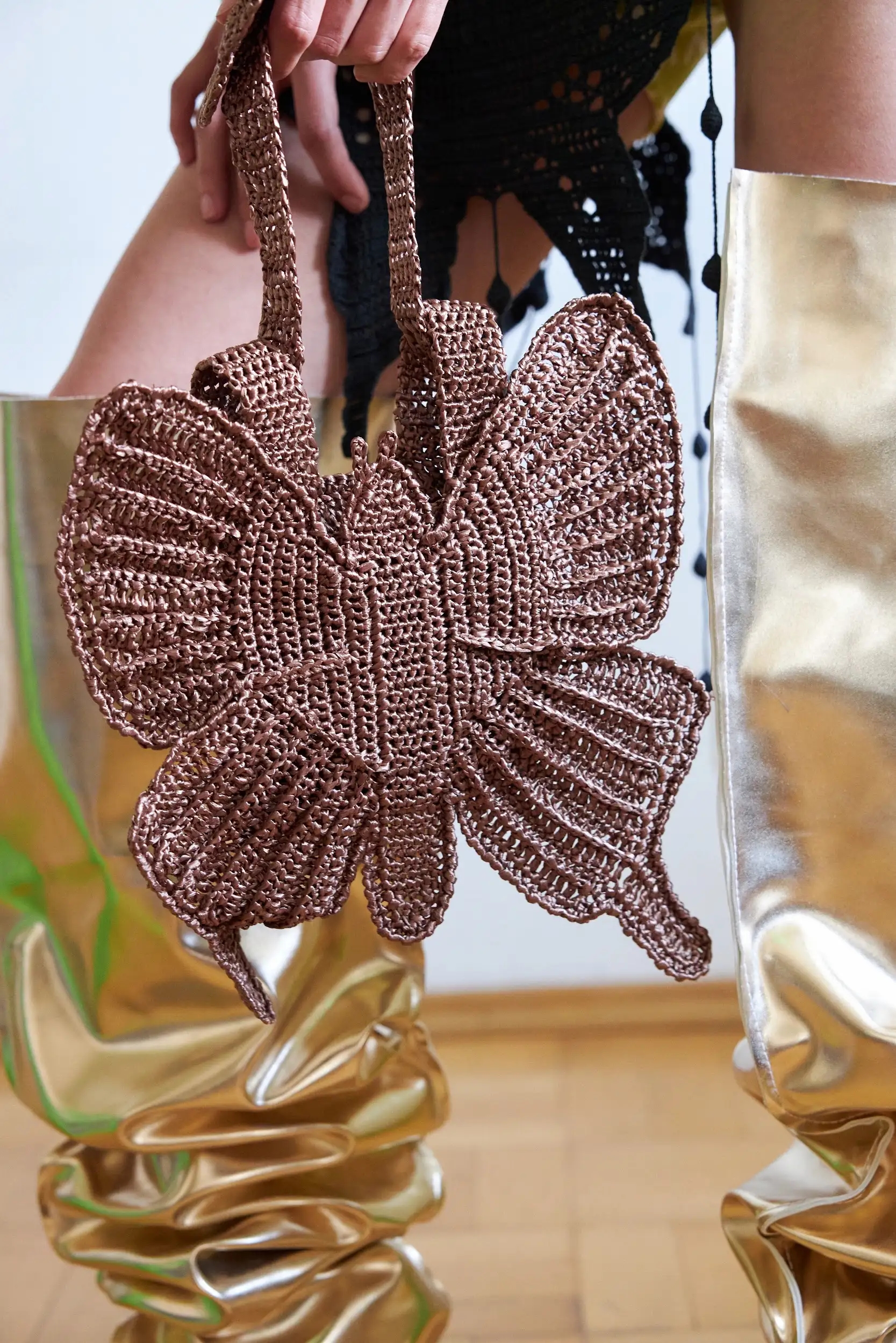 Сумка держит форму и выглядит скульптурно. Крылья рельефные, с чётким плетёным рисунком, будто броня из ниток. Цвет — как кора дерева после дождя.