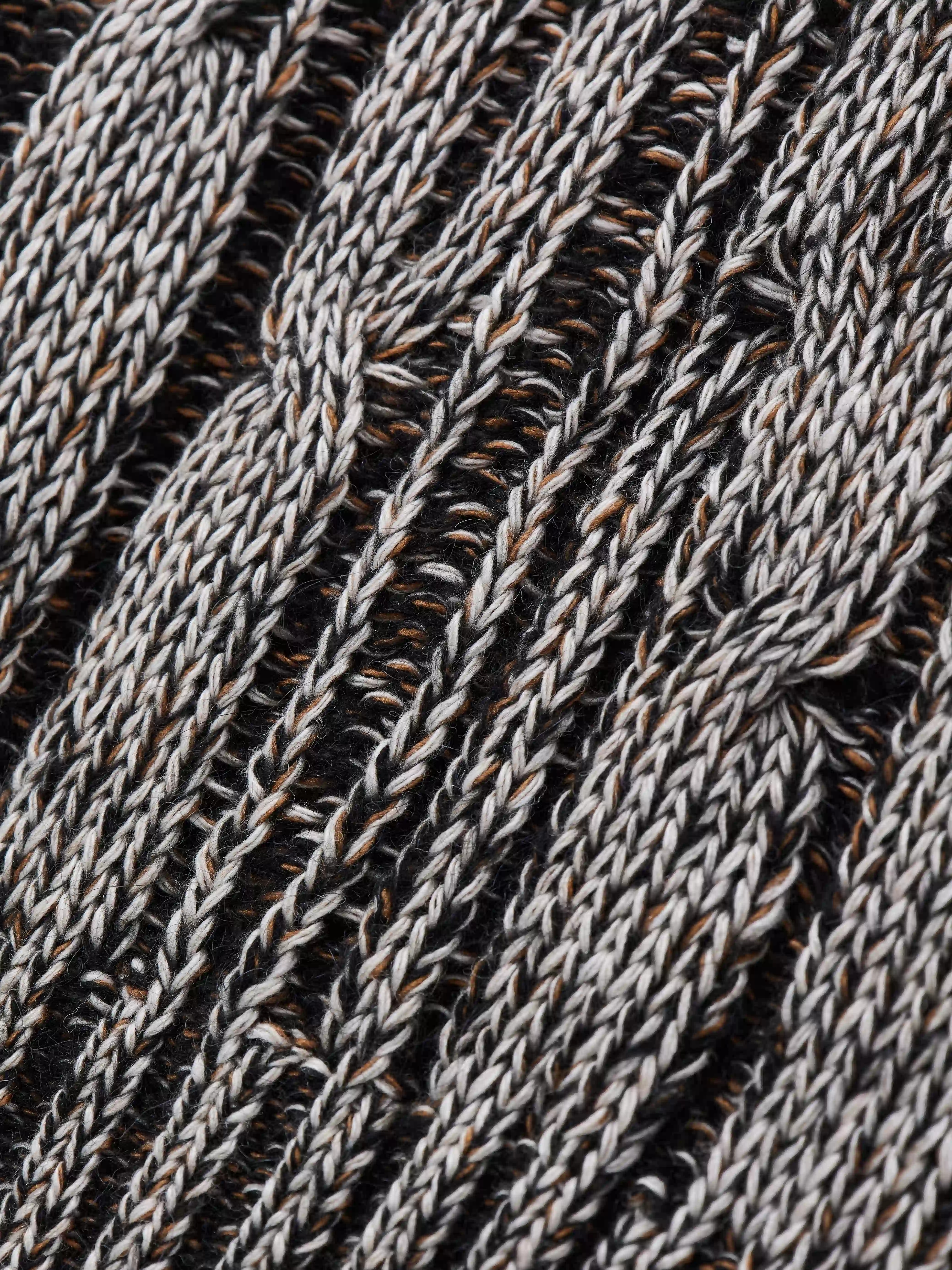 Модель вдохновлена образом «дедушкиного свитера» — тёплой ностальгической вещью с выраженным характером. Объёмный силуэт с рукавом реглан сочетает неравномерные косы и ромбовидный узор. Высокий воротник-резинка хорошо держит форму и защищает от холода. Свитер выполнен в технике платировочного вязания с использованием двух нитей, создающих эффект наслоения и выразительную фактуру.
Изделие связано из итальянской пряжи на основе шерсти с добавлением вискозы и мохера. Материал сохраняет тепло и остаётся комфортным для повседневной носки. Финальная технологическая стирка раскрывает структуру волокон, делая полотно мягким и приятным на ощупь.