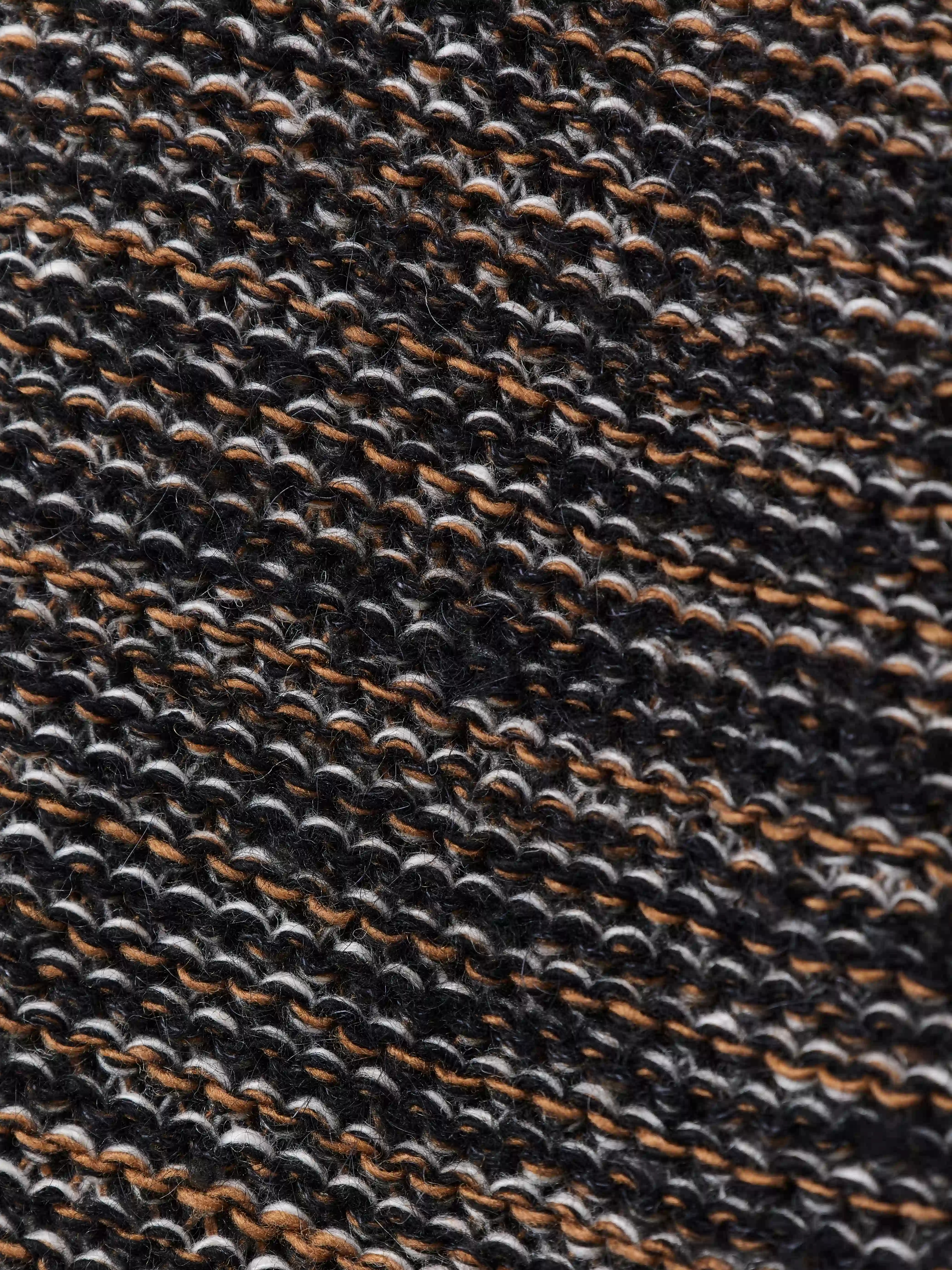 Модель вдохновлена образом «дедушкиного свитера» — тёплой ностальгической вещью с выраженным характером. Объёмный силуэт с рукавом реглан сочетает неравномерные косы и ромбовидный узор. Высокий воротник-резинка хорошо держит форму и защищает от холода. Свитер выполнен в технике платировочного вязания с использованием двух нитей, создающих эффект наслоения и выразительную фактуру.
Изделие связано из итальянской пряжи на основе шерсти с добавлением вискозы и мохера. Материал сохраняет тепло и остаётся комфортным для повседневной носки. Финальная технологическая стирка раскрывает структуру волокон, делая полотно мягким и приятным на ощупь.